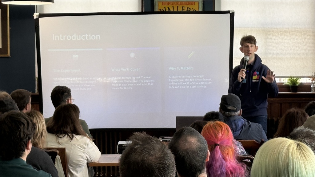 Chris stands at the front of his introduction slide with a packed room watching  image