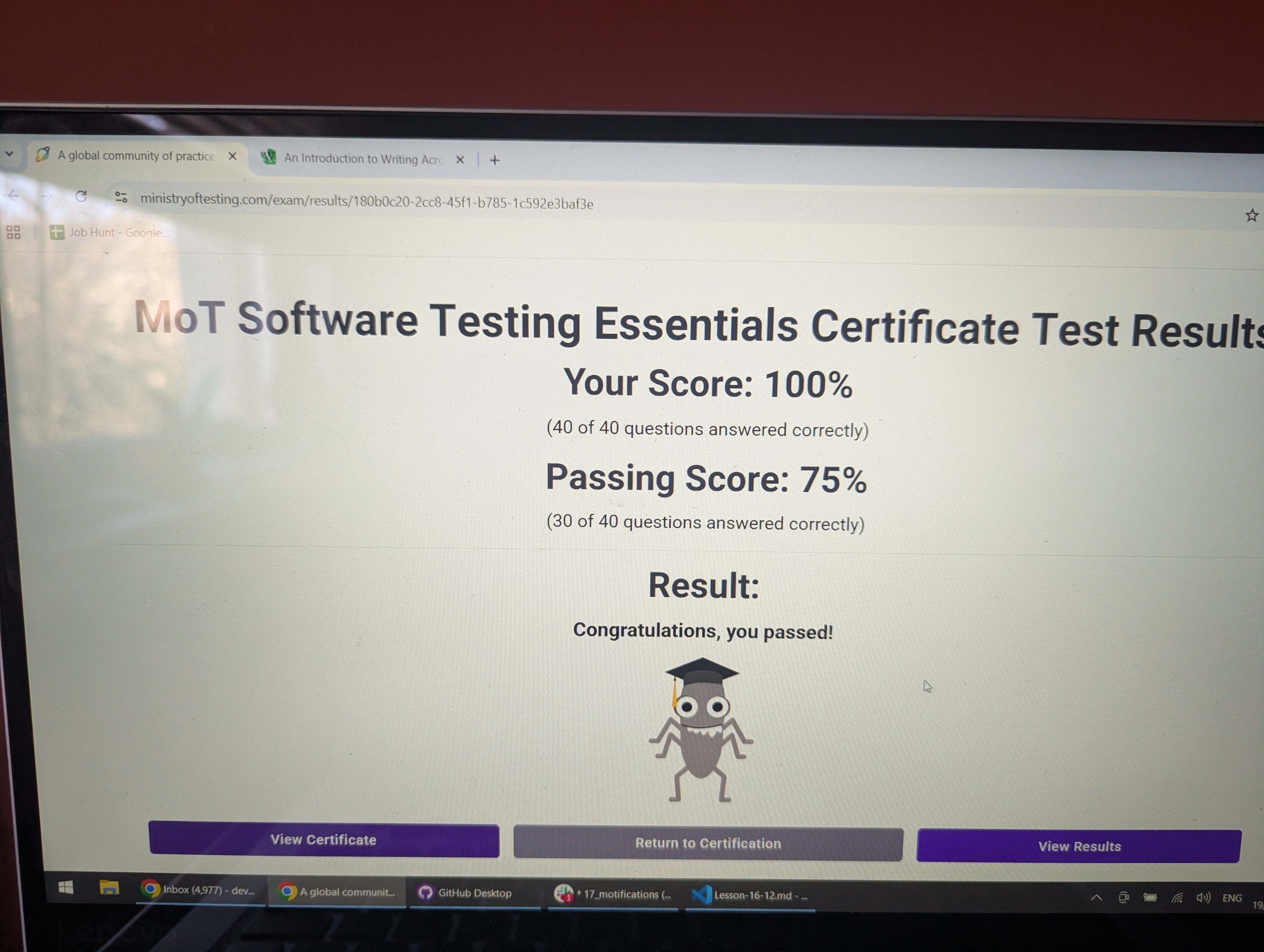 A photo of a laptop screen with the final result of a STEC (Software Testing Essentials Certificate) exam where the participant has passed. It contains an image of the MoT character Bug wearing a graduation cap.