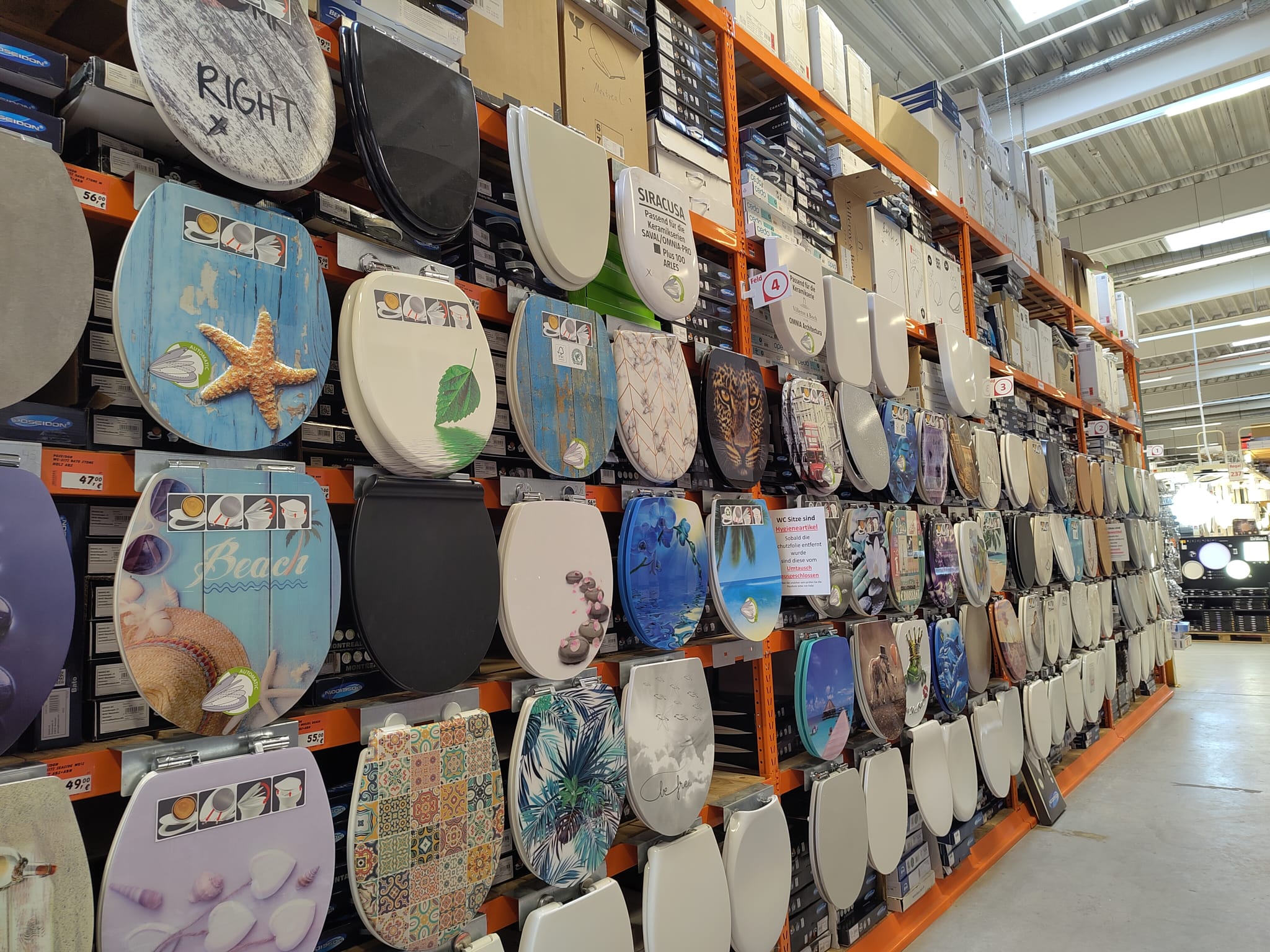 A display wall with a big selection of different toilet seats in various designs and quality.