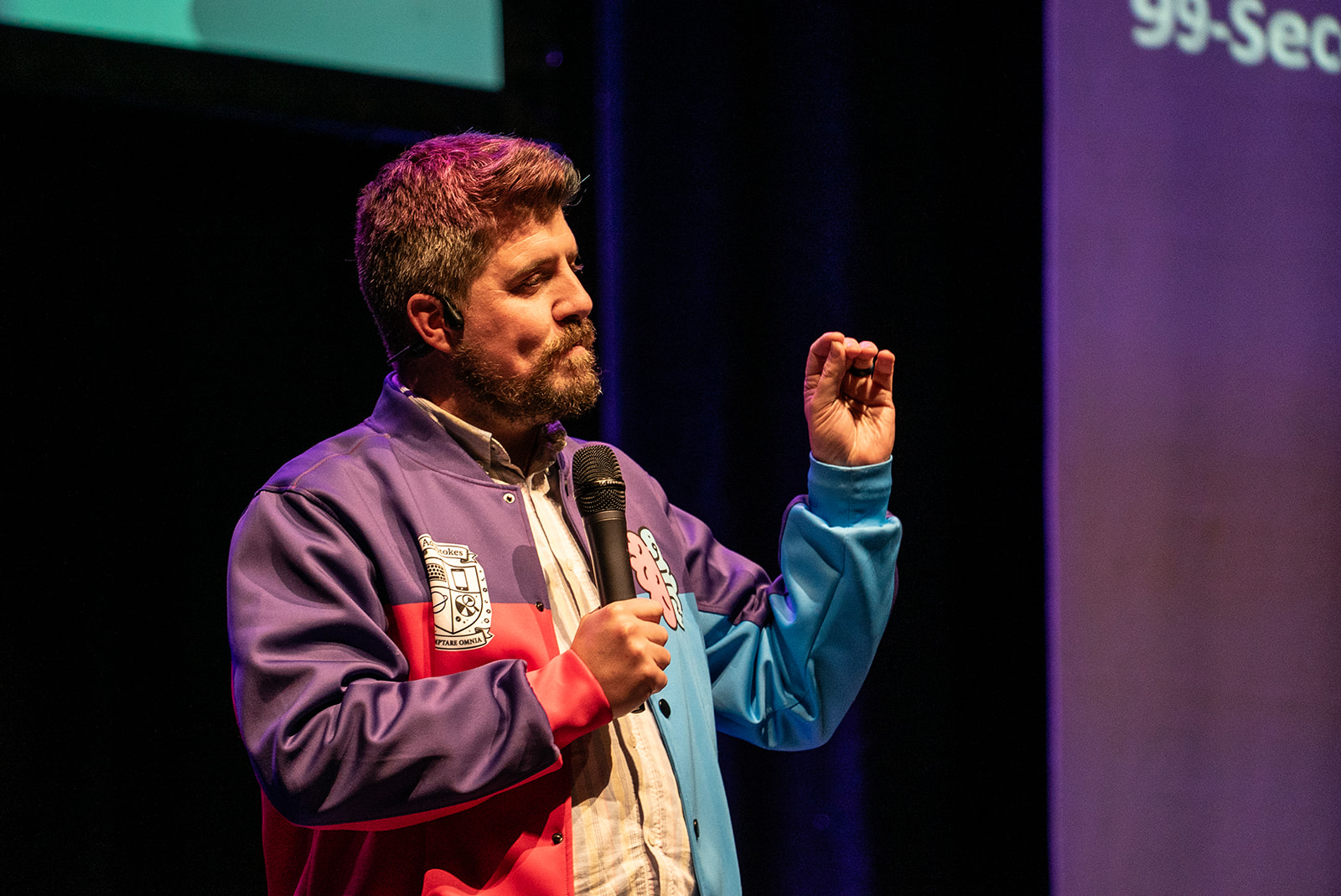 Scott Kenyon on stage with his fingers almost pinching.