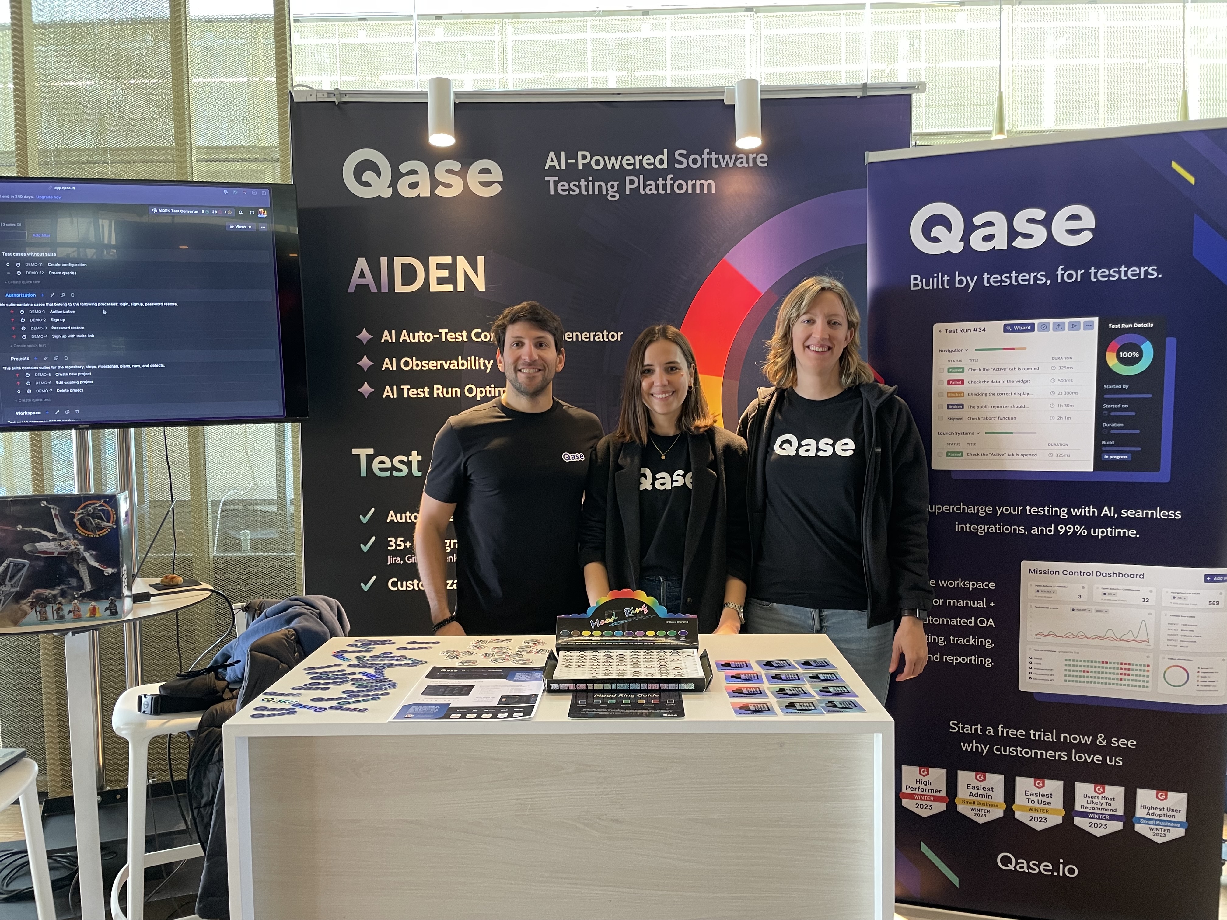 Team Qase pose infront of their sponsor booths.