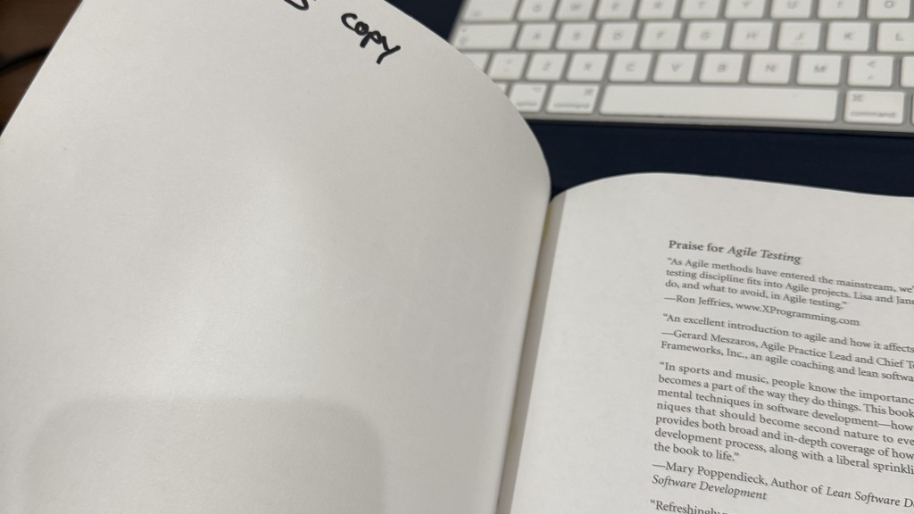 Photo of a 1st edition Agile Testing book by Lisa Crispin and Janet Gregory. It has "Tomesy's copy" written in the to... image