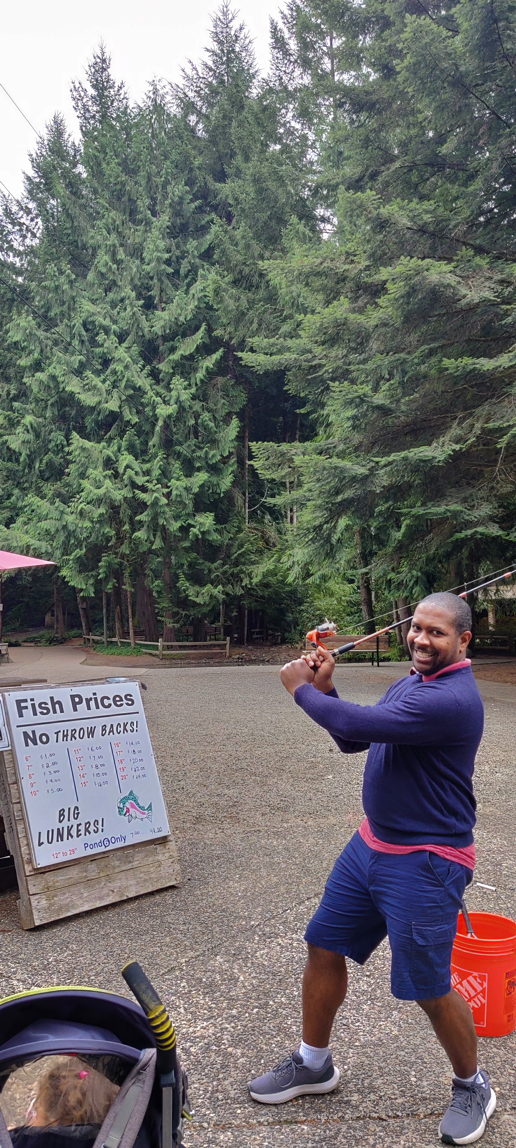 I'm in a throwing stance while holding a fishing rod in front of a sign in Portland, USA