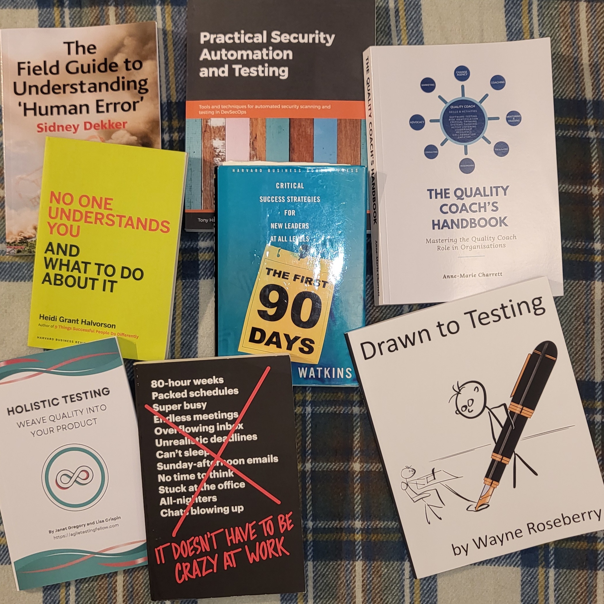 The following books are arranged in a messy grid on top of a blue-checked rug:
1. The Field Guide to Understanding ‘Human Error’ by Sidney Dekker
2. Practical Security Automation and Testing
3. The Quality Coach’s Handbook by Anne-Marie Charrett
4. No One Understands You And What To Do About It by Heidi Grant Halvorson
5. The First 90 Days by Watkins
6. Holistic Testing by Janet Gregory and Lisa Crispin
7. It Doesn’t Have To Be Crazy At Work
8. Drawn to Testing by Wayne Roseberry