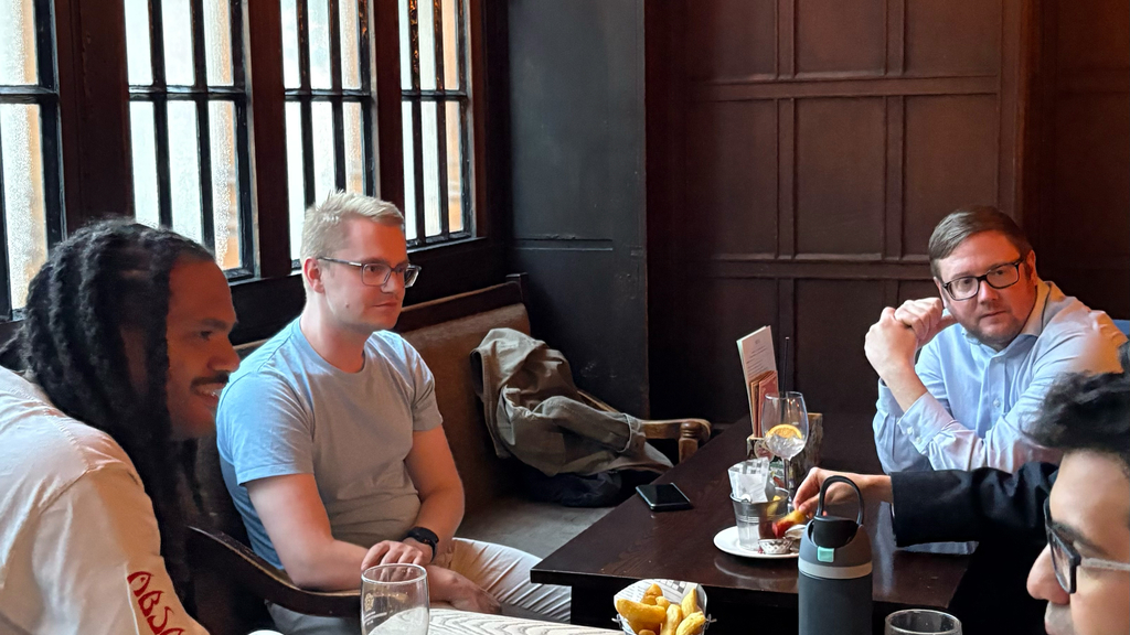 A group of men sitting in a pub.  image