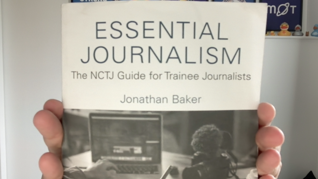 This photo is of me holding a book of Essential Journalism, the NCTJ guide for trainer journalists. By Jonathan Baker. image