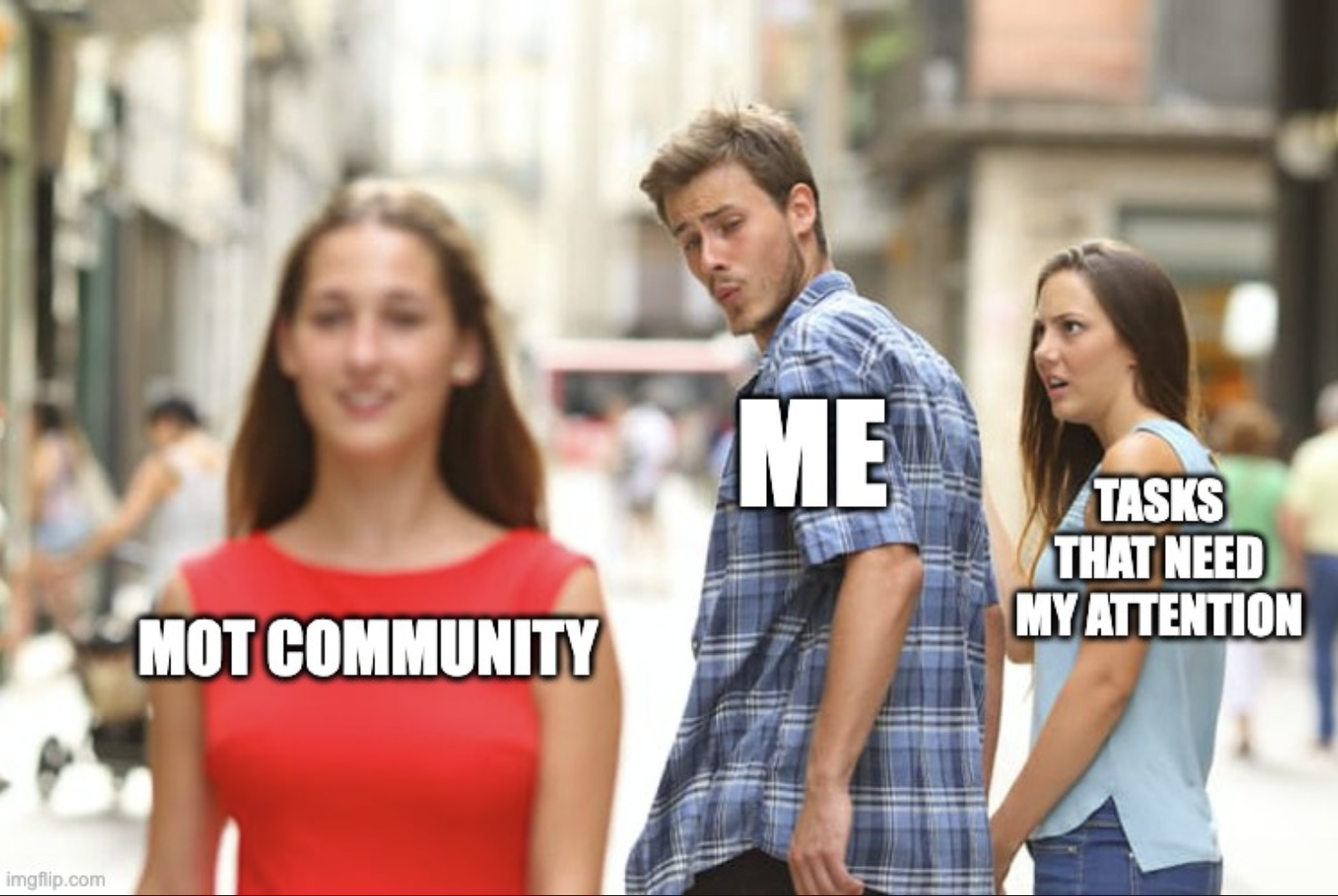 A popular meme format known as "Distracted Boyfriend." In the image, a man labeled "ME" is walking with a woman labeled "TASKS THAT NEED MY ATTENTION" but is turning around to look at another woman walking past him, who is labeled "MOT COMMUNITY." The woman he's with looks shocked and annoyed, while the woman he's looking at appears confident and is wearing a red dress. The meme humorously suggests the person is ignoring their responsibilities in favor of engaging with the MOT community.