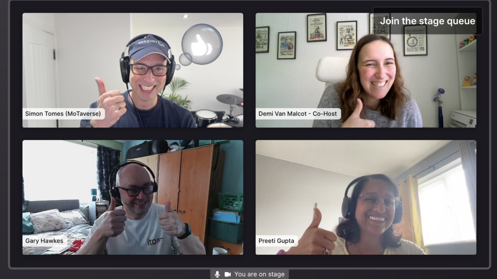 A screenshot of a four-person video call, arranged in a two-by-two grid on a dark interface. All participants are smi... image
