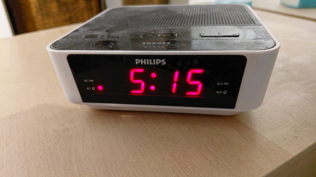 An alarm clock displaying the alarm set for 5:15 AM image