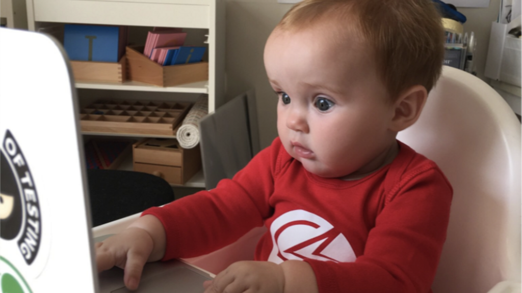 Piper with a laptop on a high chair. image