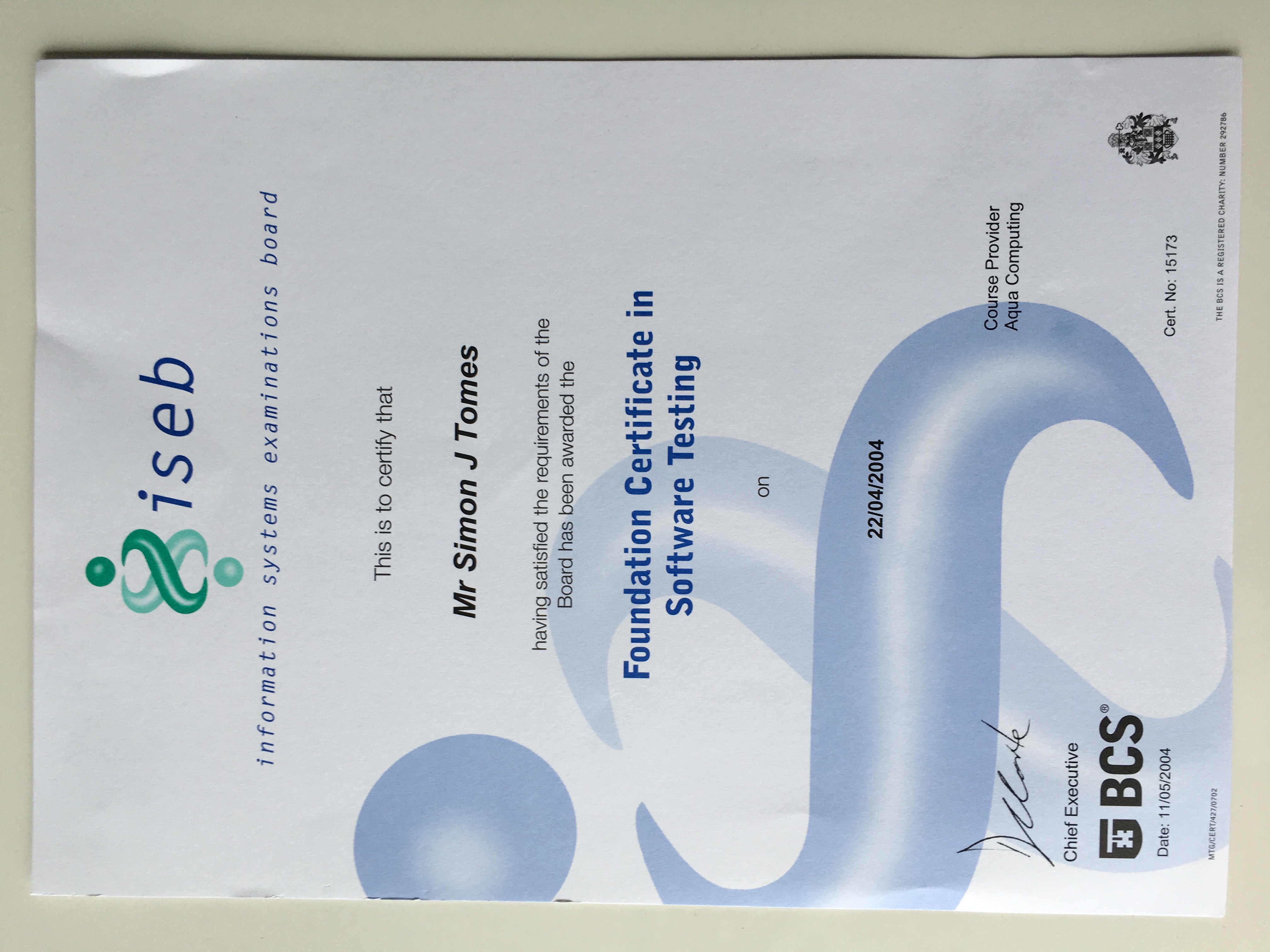 A certification document for "Foundation Certificate in Software Testing" from "ISEB" (Information Systems Examinations Board), awarded to "Mr Simon J Tomes" on "22/04/2004." The certificate is signed by the "Chief Executive" of "BCS" and also lists "Aqua Computing" as the "Course Provider." The certification number is "15173" and the document is dated "11/05/2004."