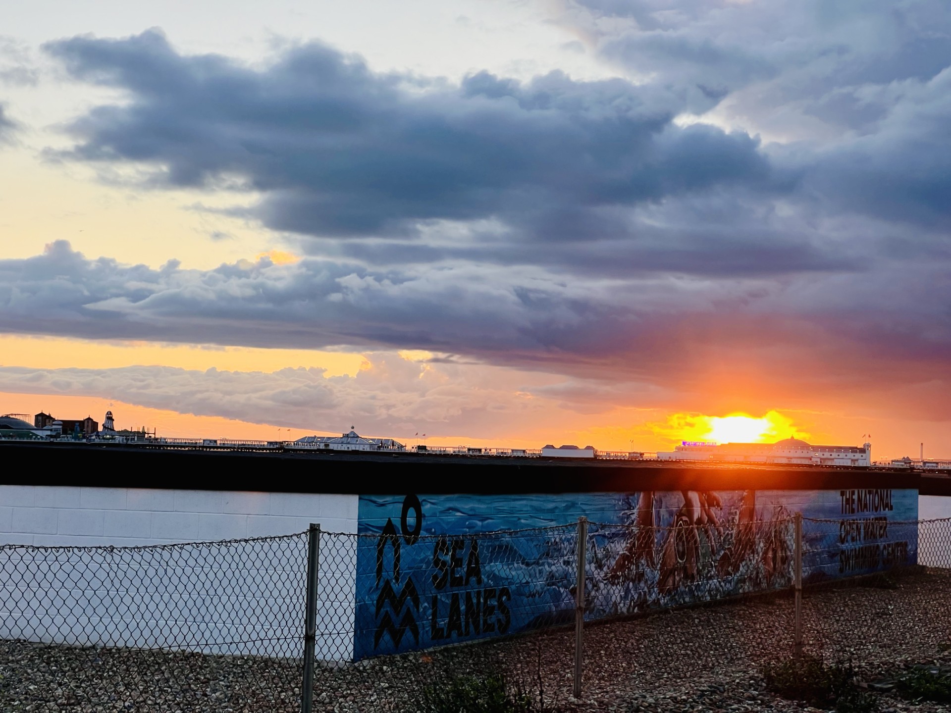 The sun setting behind Brighton pier with storm clouds building over Brighton.