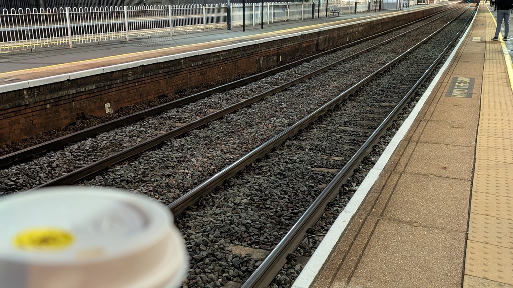 Train platform taken 6.20am with coffee cup image