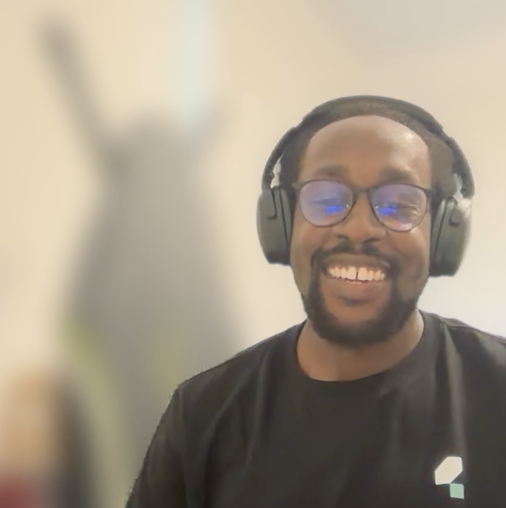 A man on a video call. There's a blurred ironing board in the background that looks a bit like the MoTaverse Bug char... image