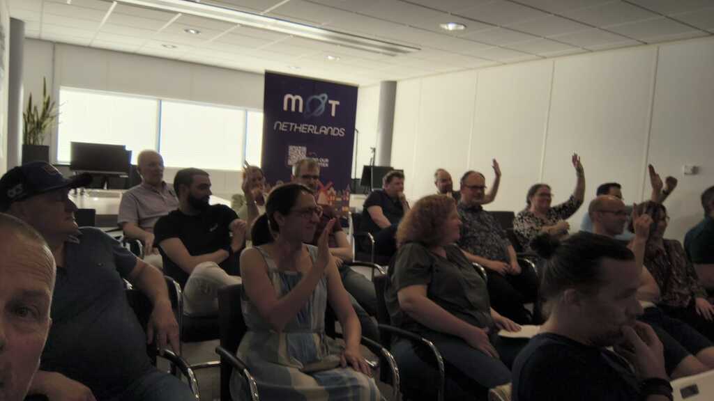 Attendees raising their hand at the MoT-NL Chapter Meeting for a question by Veerle image