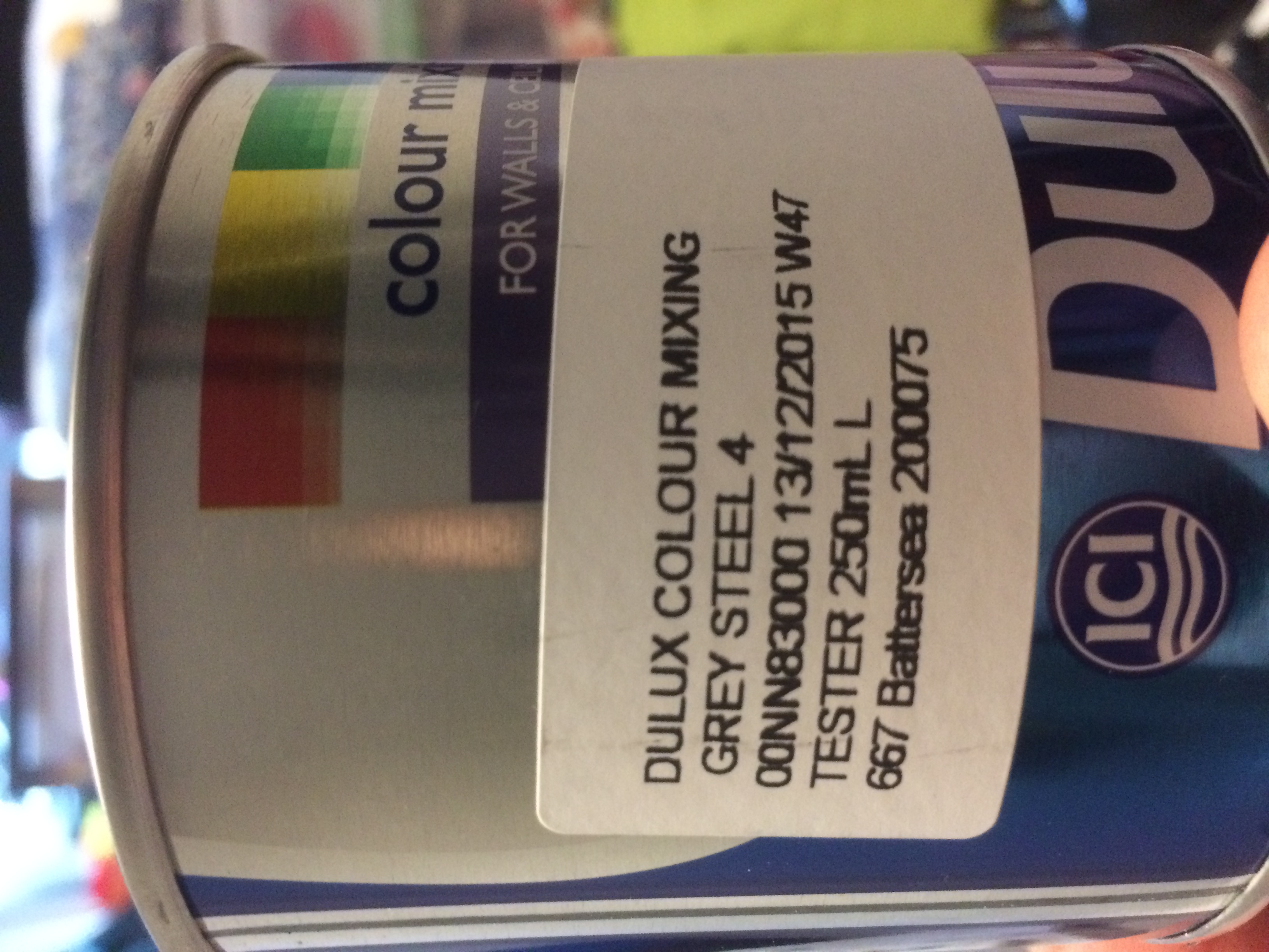 A paint tin with the word "tester" on it. Rest of text:  DULUX COLOUR MIXING. GREY STEEL 4. CONN83000 13/12/2015 W47. TESTER 250mL L. 667 Battersea 200075