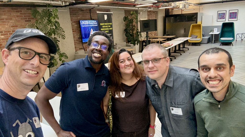 A group of people posing for a selfie in an event space. 