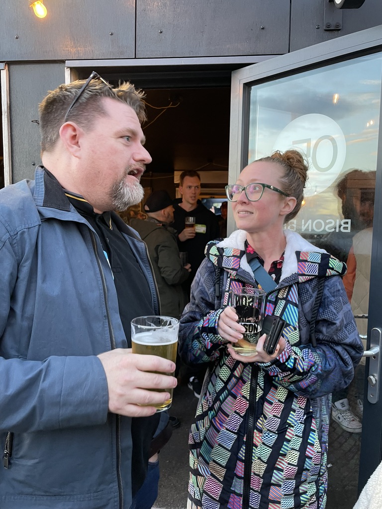 Photo of Karen and Dan chatting away, socially at a bar.