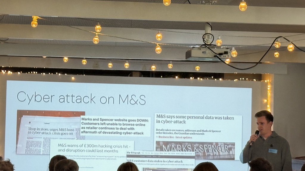 Adam in front of a slide with clips from articles about the M&amp;S cyber attack  image