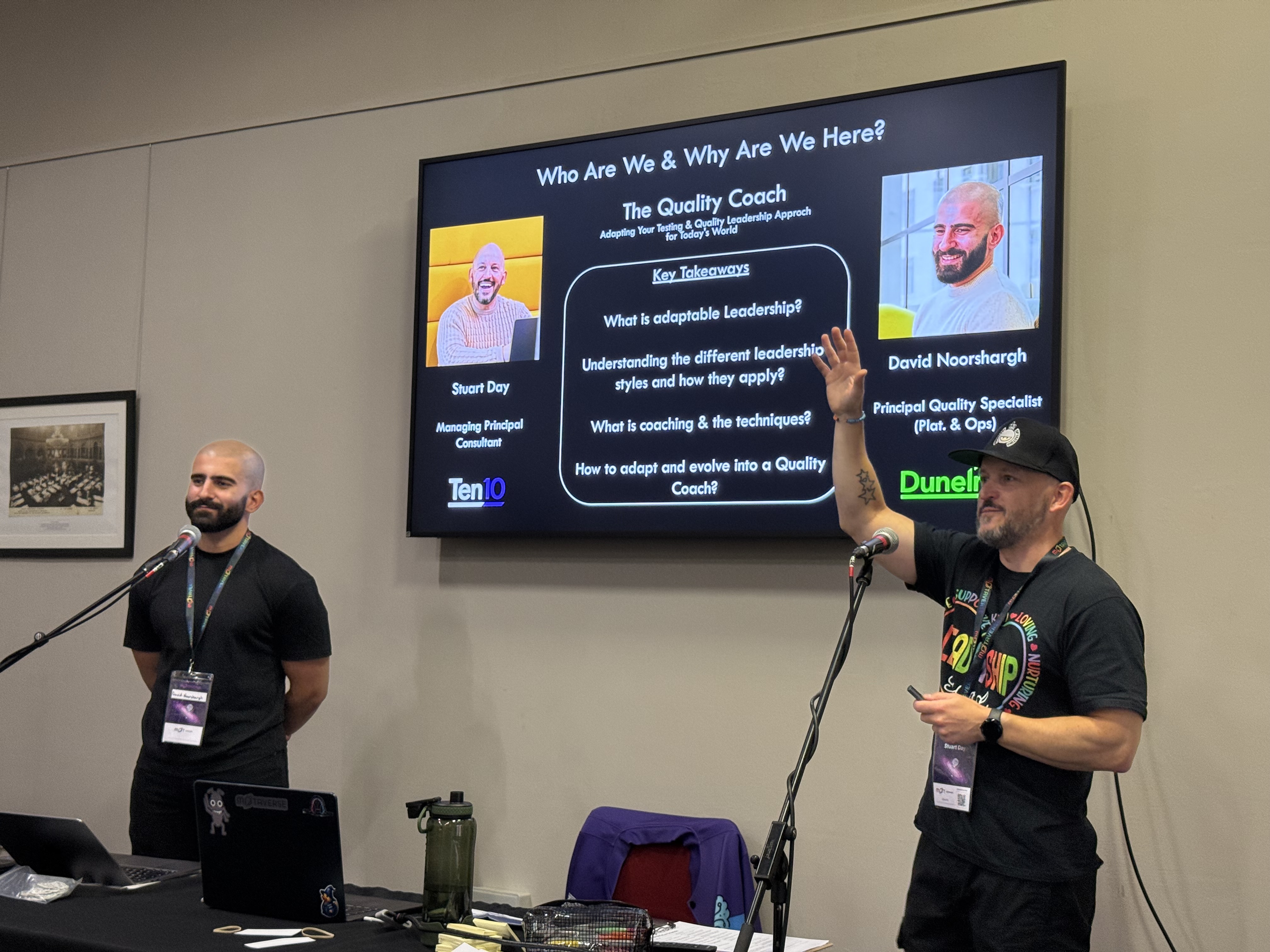 Stu Day and David Noorshargh standing in front of a large TV displaying their introductory slide for the workshop. 
