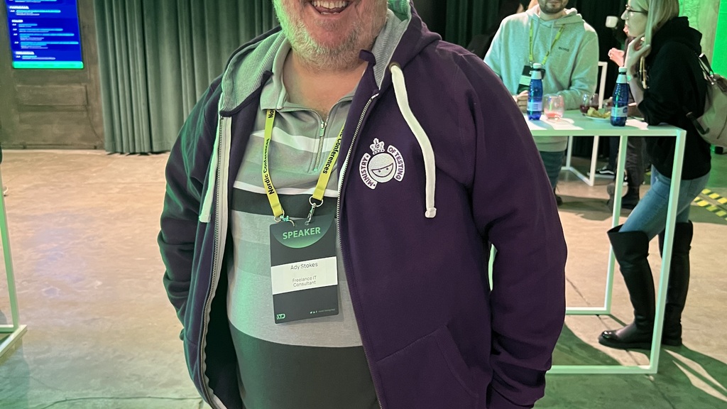 Ady Stokes rocking a purple MoT hoodie with a big smile at Nordic Testing Days. 
