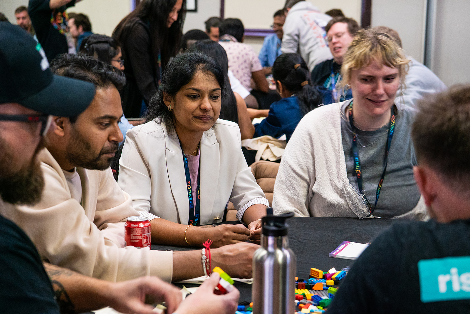Quality people sitting around a table collaborating and learning via Lego