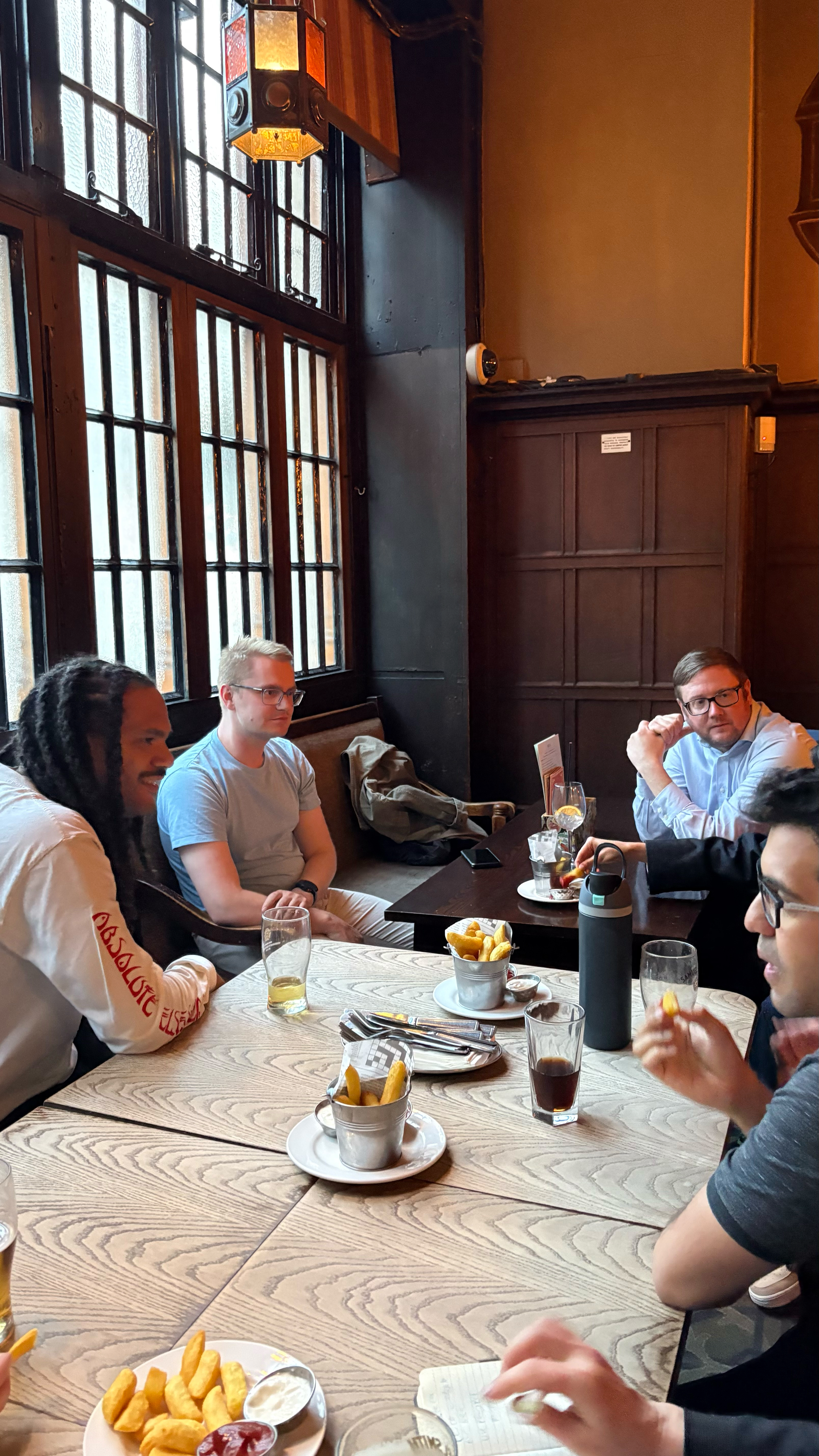A group of men sitting in a pub.  image