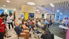 A speaker facing an engaged audience of about 70 people.  image