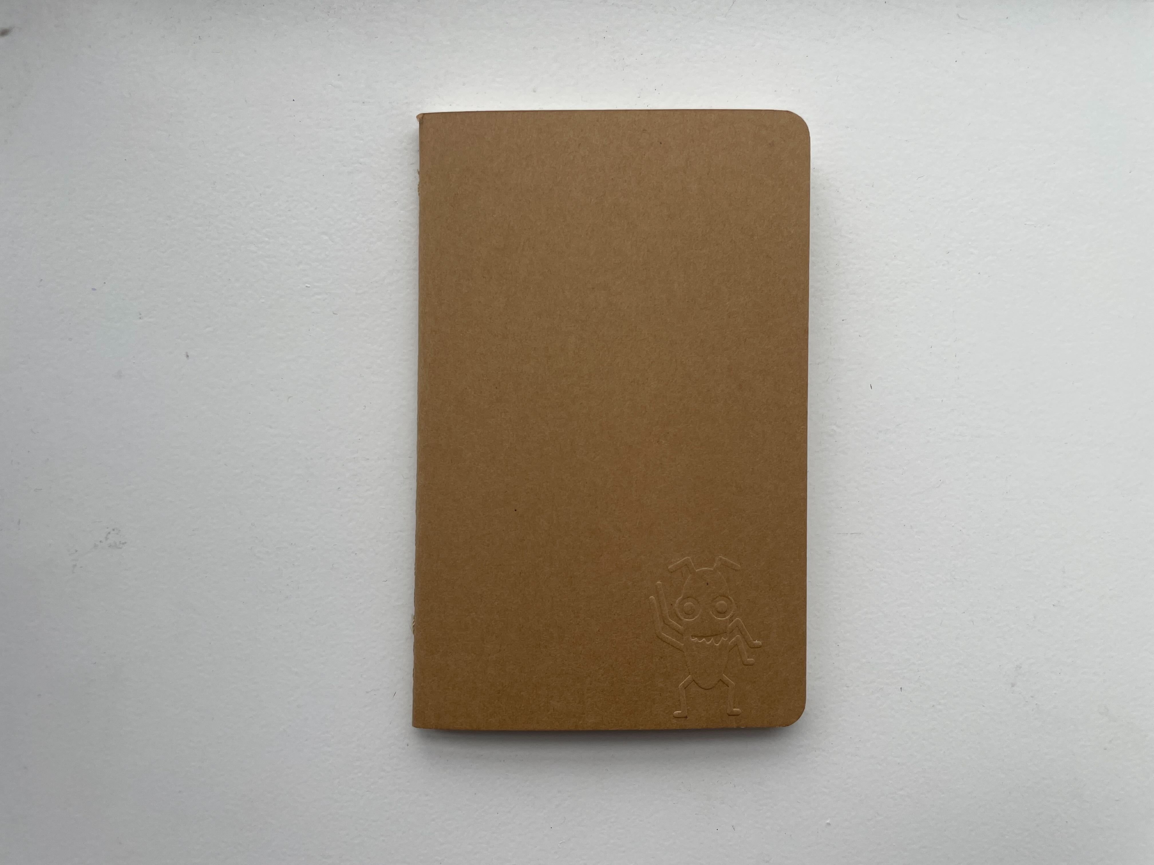 A photo of a notebook with Bug imprinted into it.