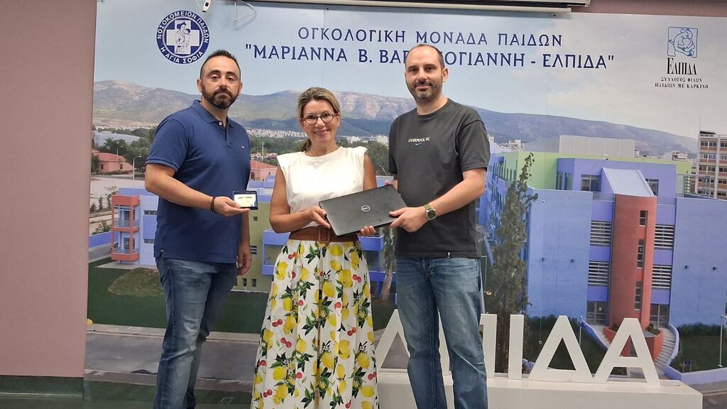 Petros and Giorgos are handing the laptops over to the Foundation's representative. image