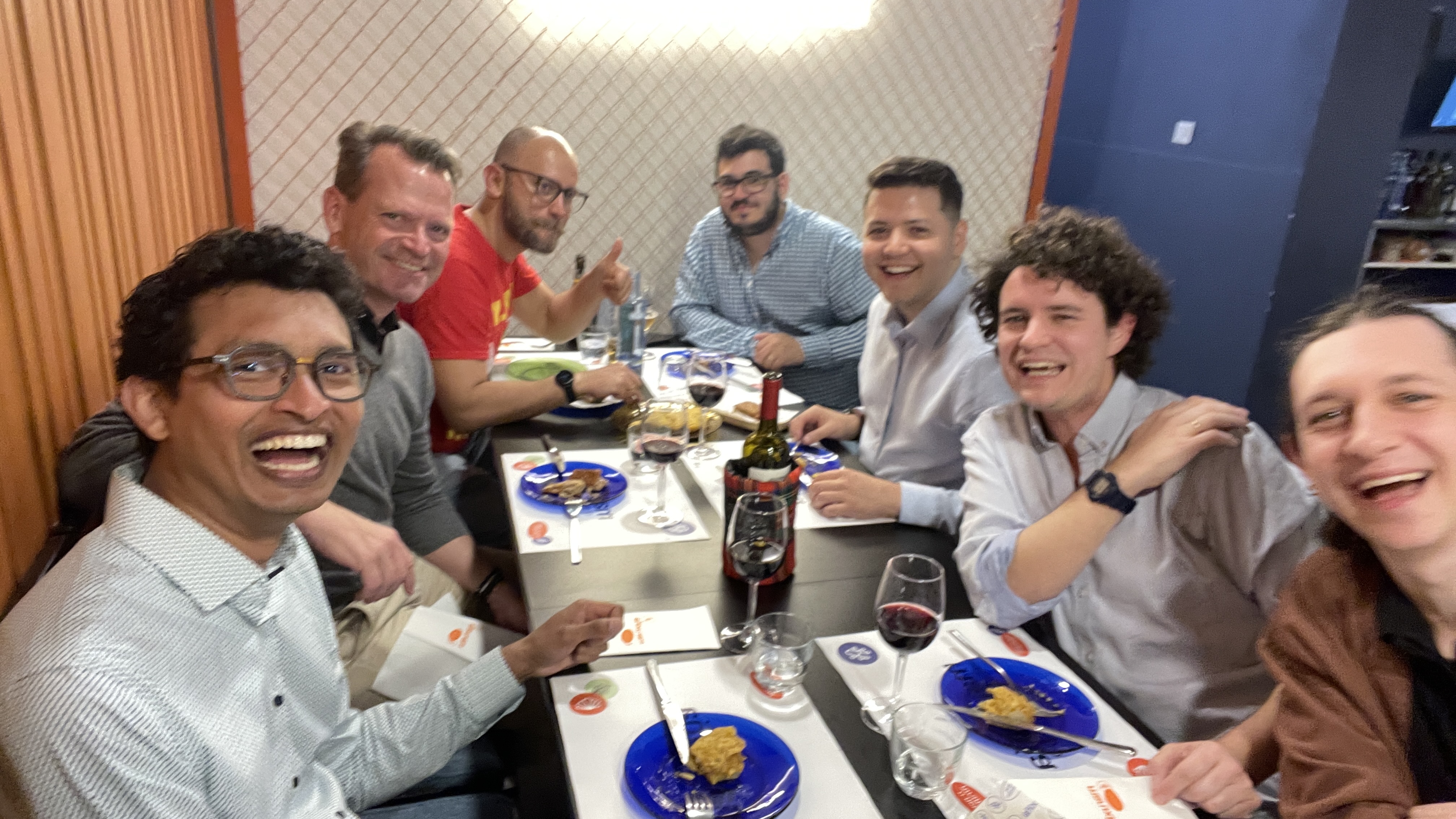 At the Selenium Conf 2025 speakers' dinner at Maruxiña, a group of speakers including Mazin Inaad, João Proença, Kiryl Predkel, Leandro Melendez, and Giannis Papadakis smile and laugh around a table with wine, Galician tapas, and good vibes.