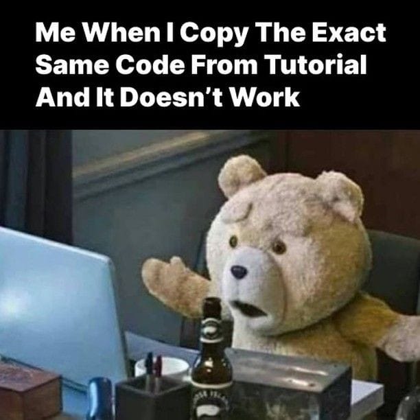 A teddy bear sits at a desk in front of a laptop, with a perplexed expression and arms raised in frustration. The text above reads, "Me When I Copy The Exact Same Code From Tutorial And It Doesn't Work.
