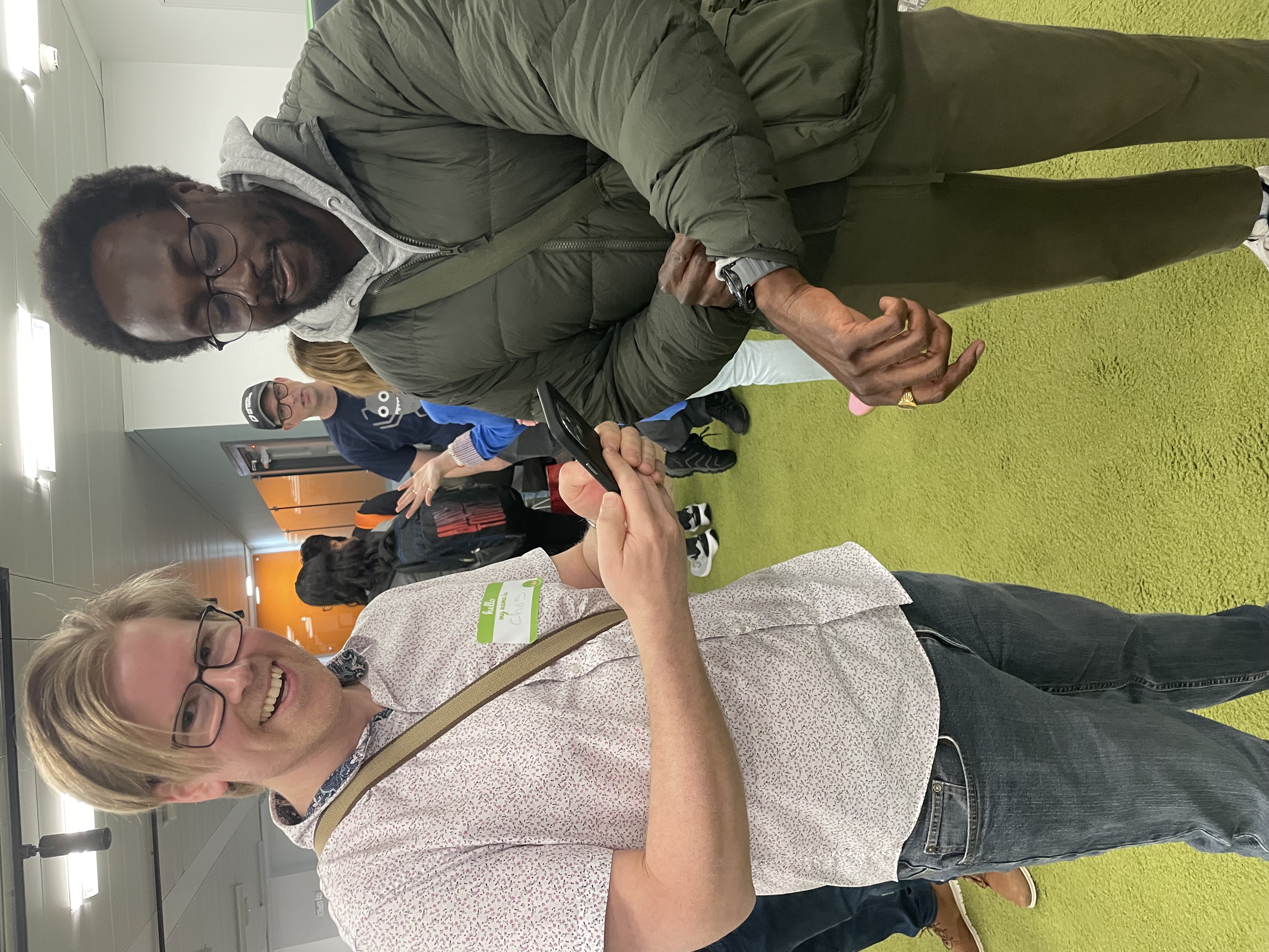 Chris is on the left trying to scan Eamon's QR code on his watch.