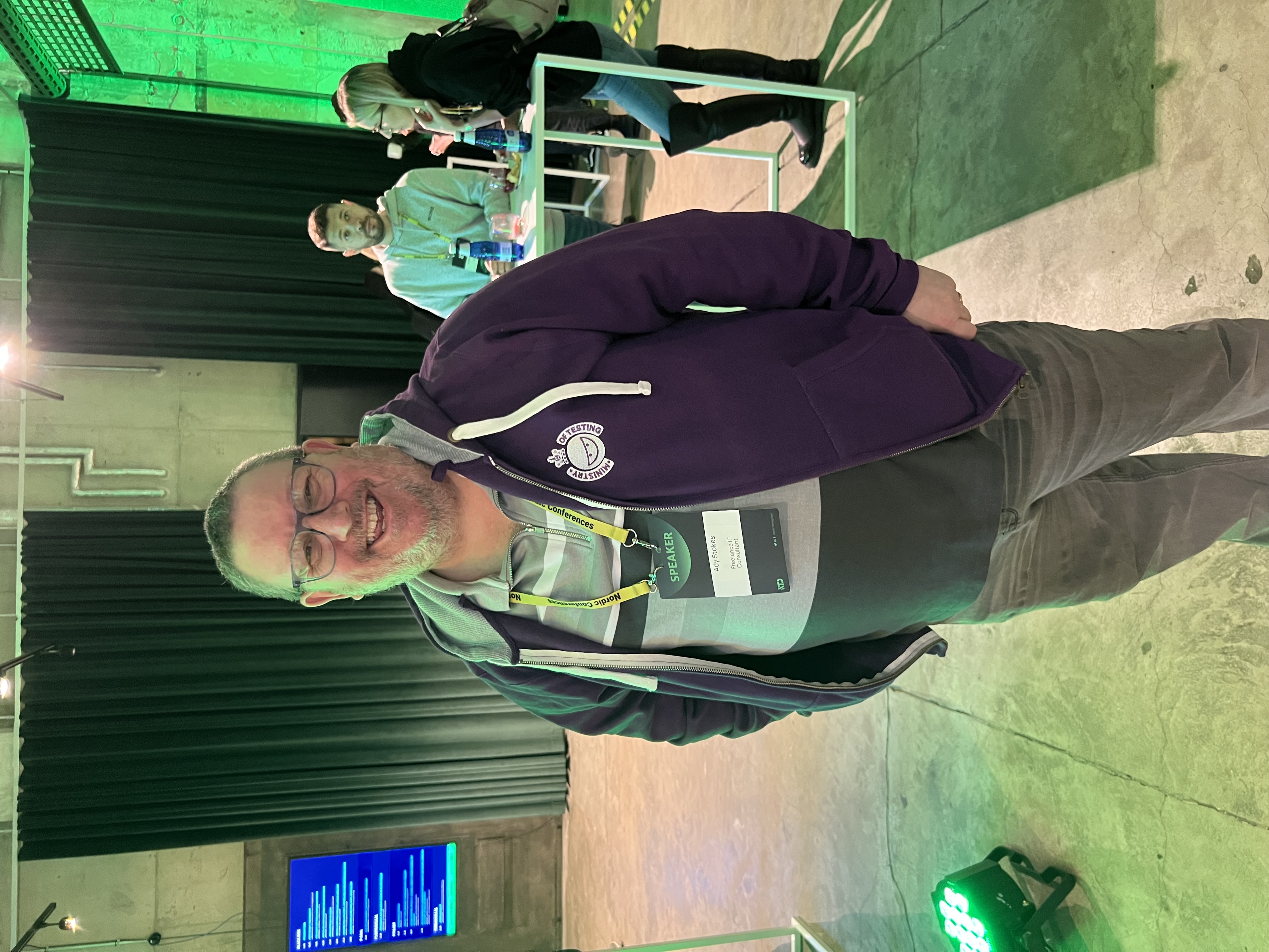 Ady Stokes rocking a purple MoT hoodie with a big smile at Nordic Testing Days. 