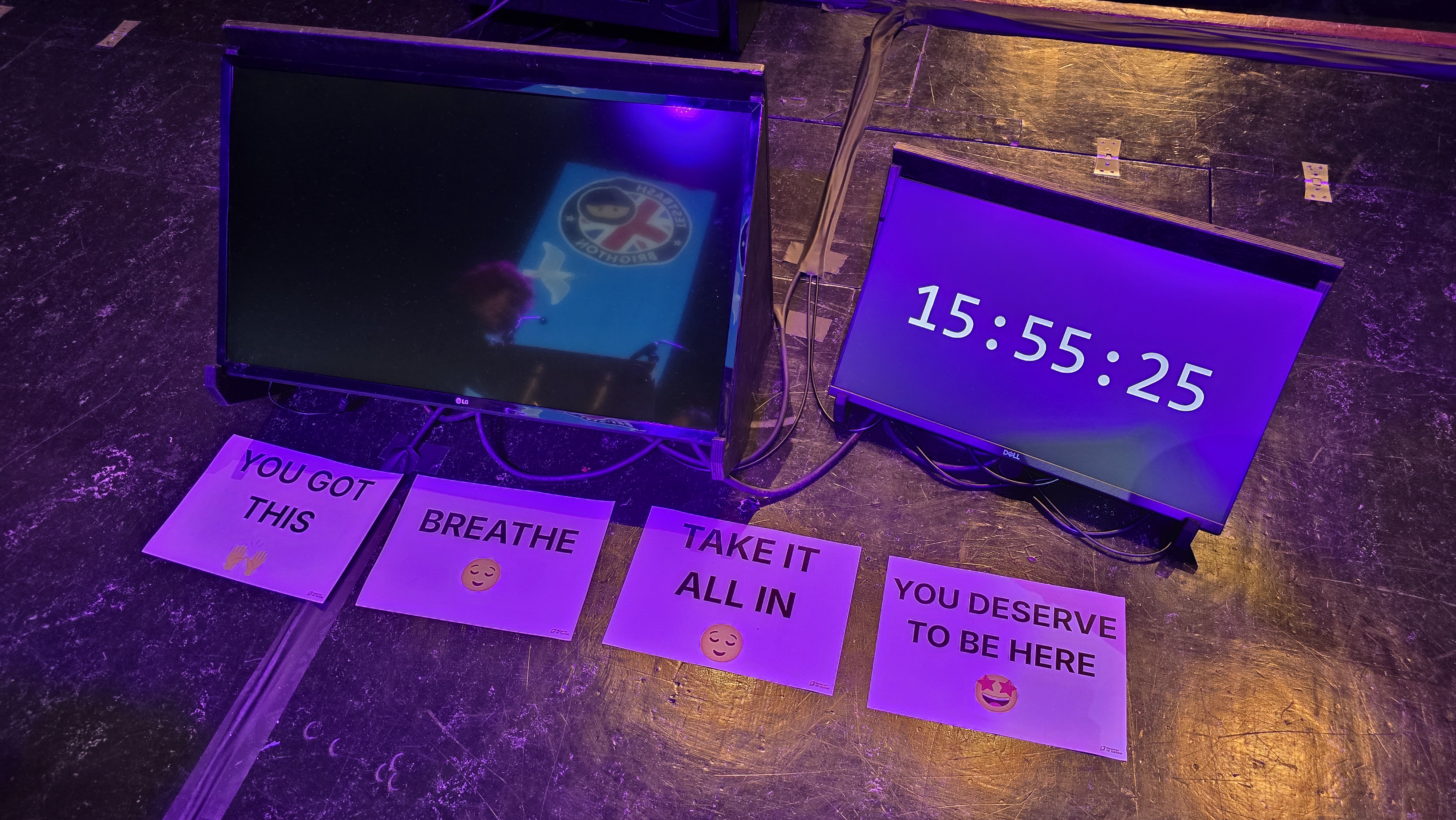 Picture of the support screens on the main stage showing four A4 pages on the floor with the following messages: 'YOU GOT THIS', 'BREATHE', 'TAKE IT ALL IN' and 'YOU DESERVE TO BE HERE'