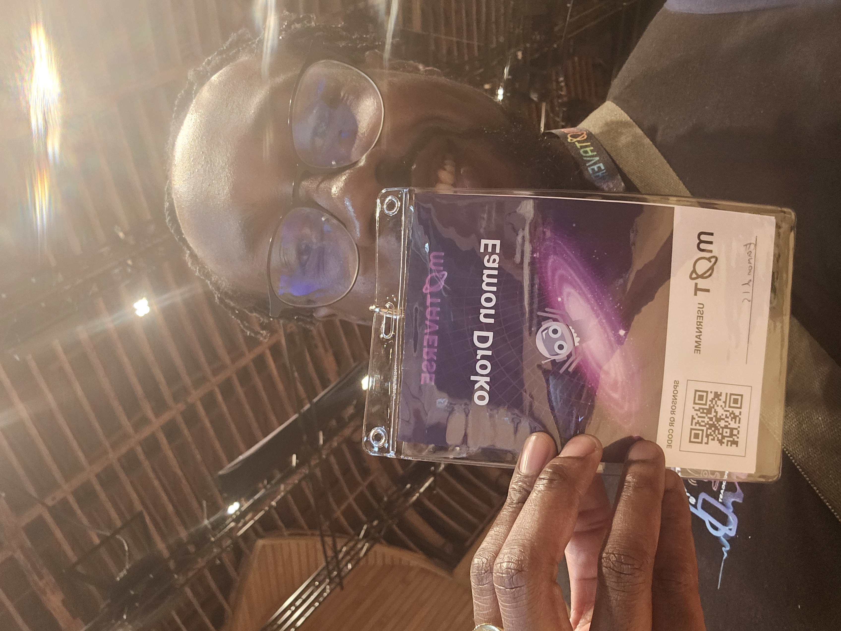 Selfie of black man with glasses holding name badge that reads "Eamon Droko". The image is mirrored so his name is writted backwards.

