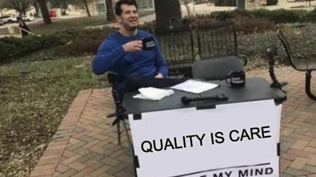 A meme featuring a man sitting at a table outdoors with a sign that reads “QUALITY IS CARE” above the phrase “CHANGE MY MIND.” The man is smiling and holding a coffee mug, suggesting confidence in his opinion. The setting is a park-like area with brick pathways, trees, and empty benches in the background.