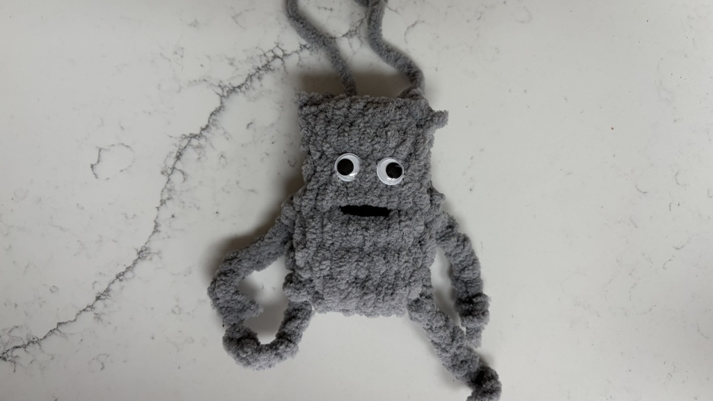 A hand crafted mini bug bag with google eyes image