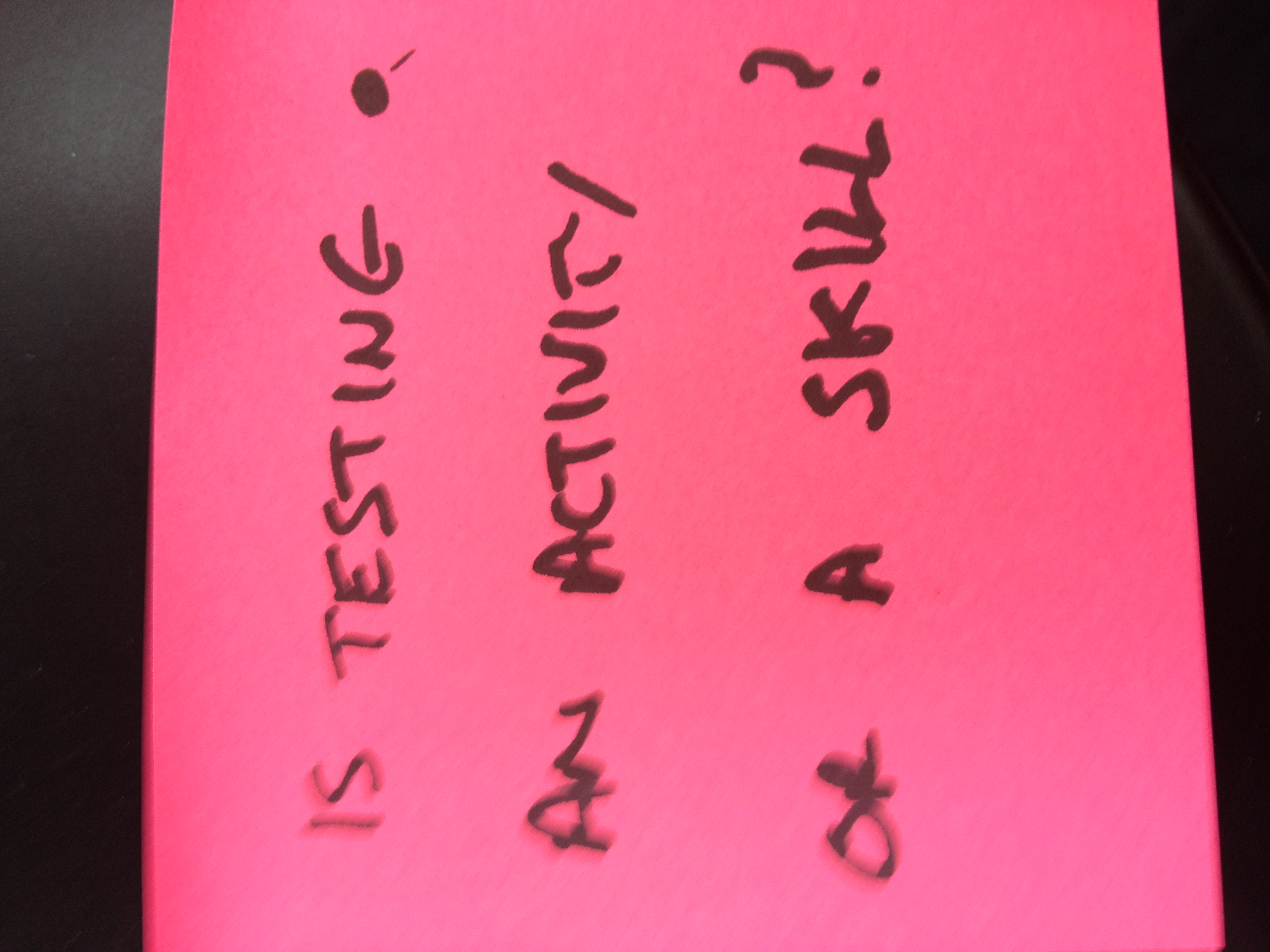 Red Post it in hand writing block letters: Is Testing an activity or a skill?