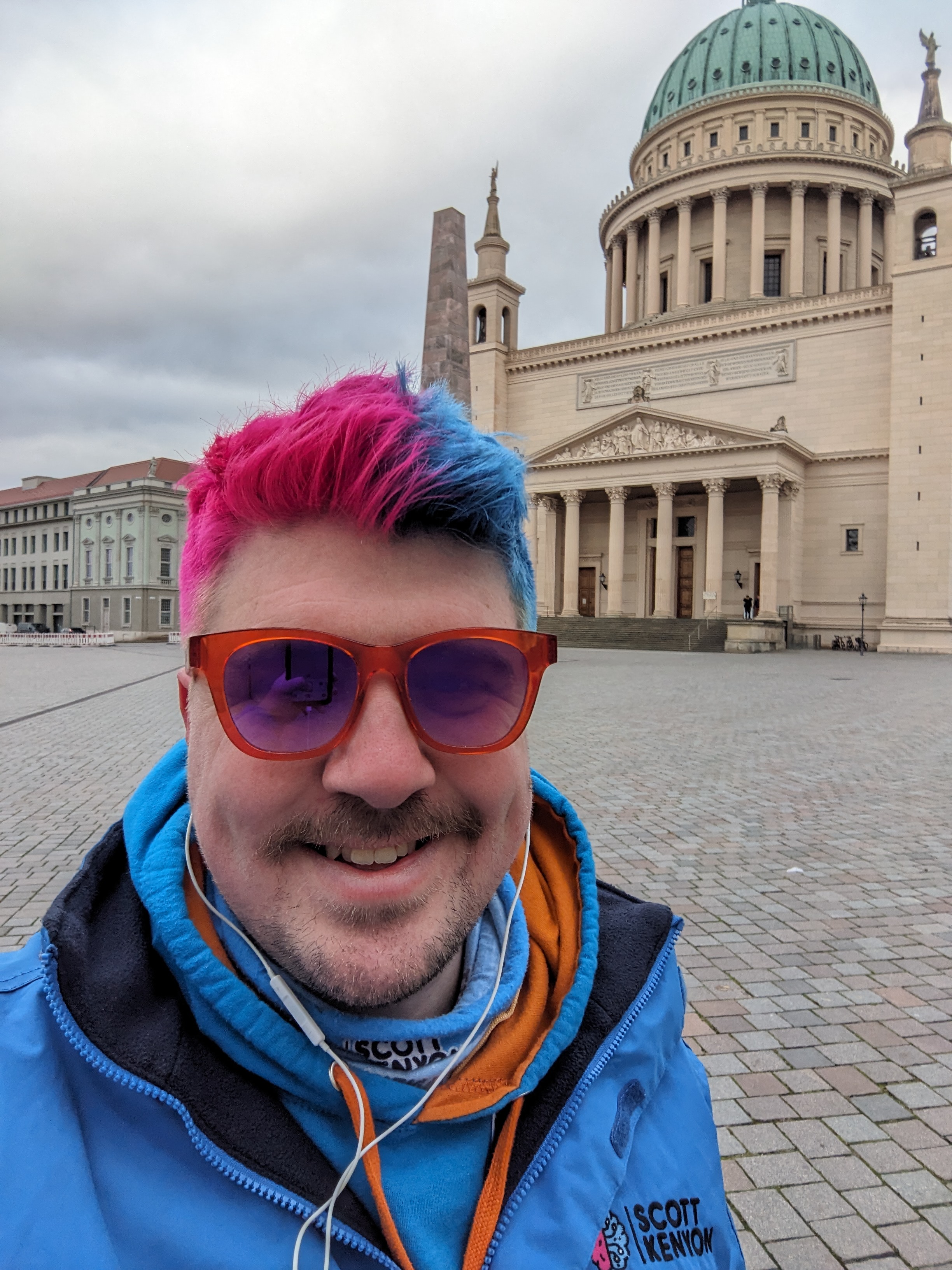 Selfie of Scott in a suit with colours in his hair - pink and blue half and half. 