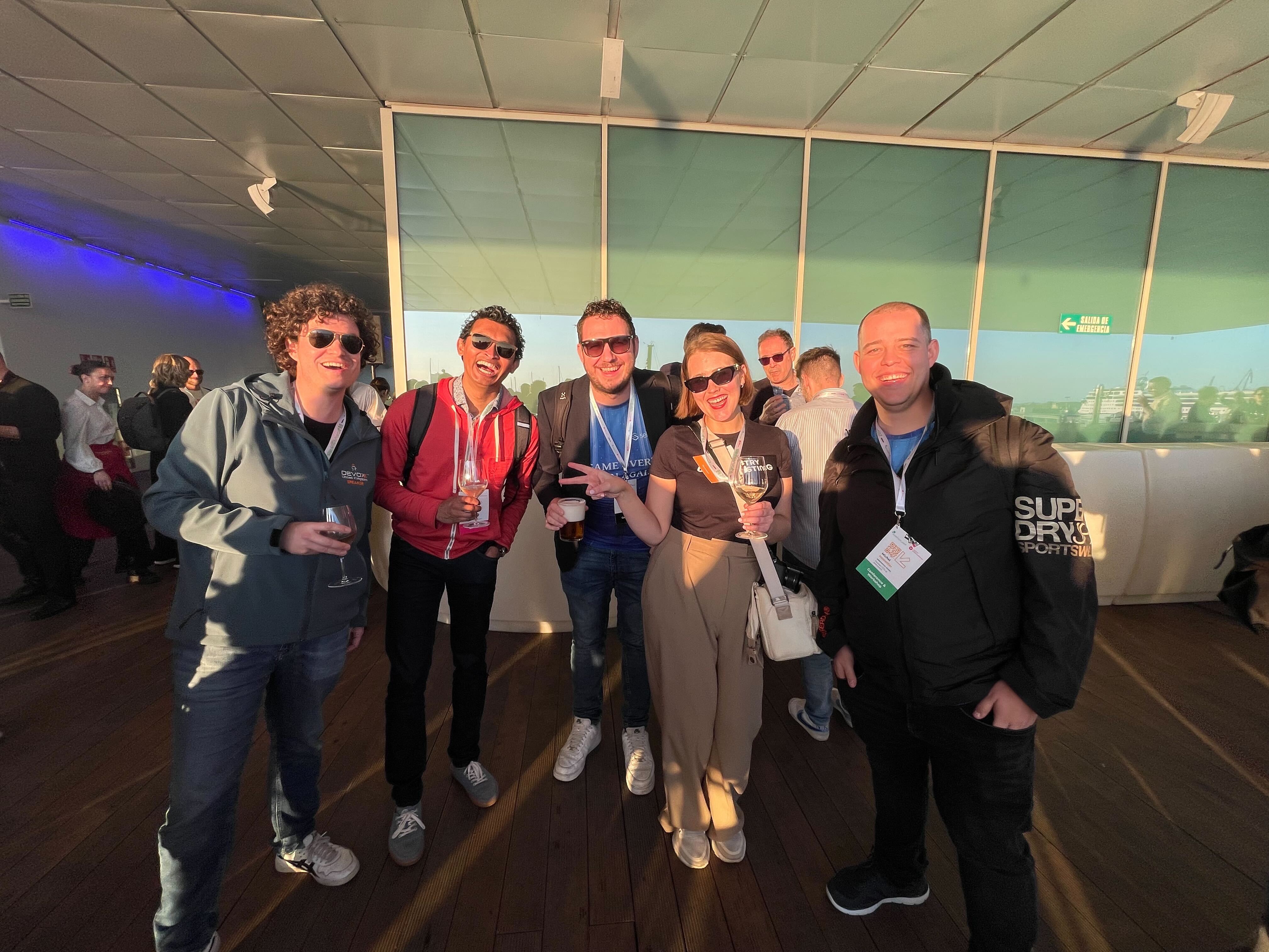 A group of happy testing people, many with sunglasses on posting for the camera.