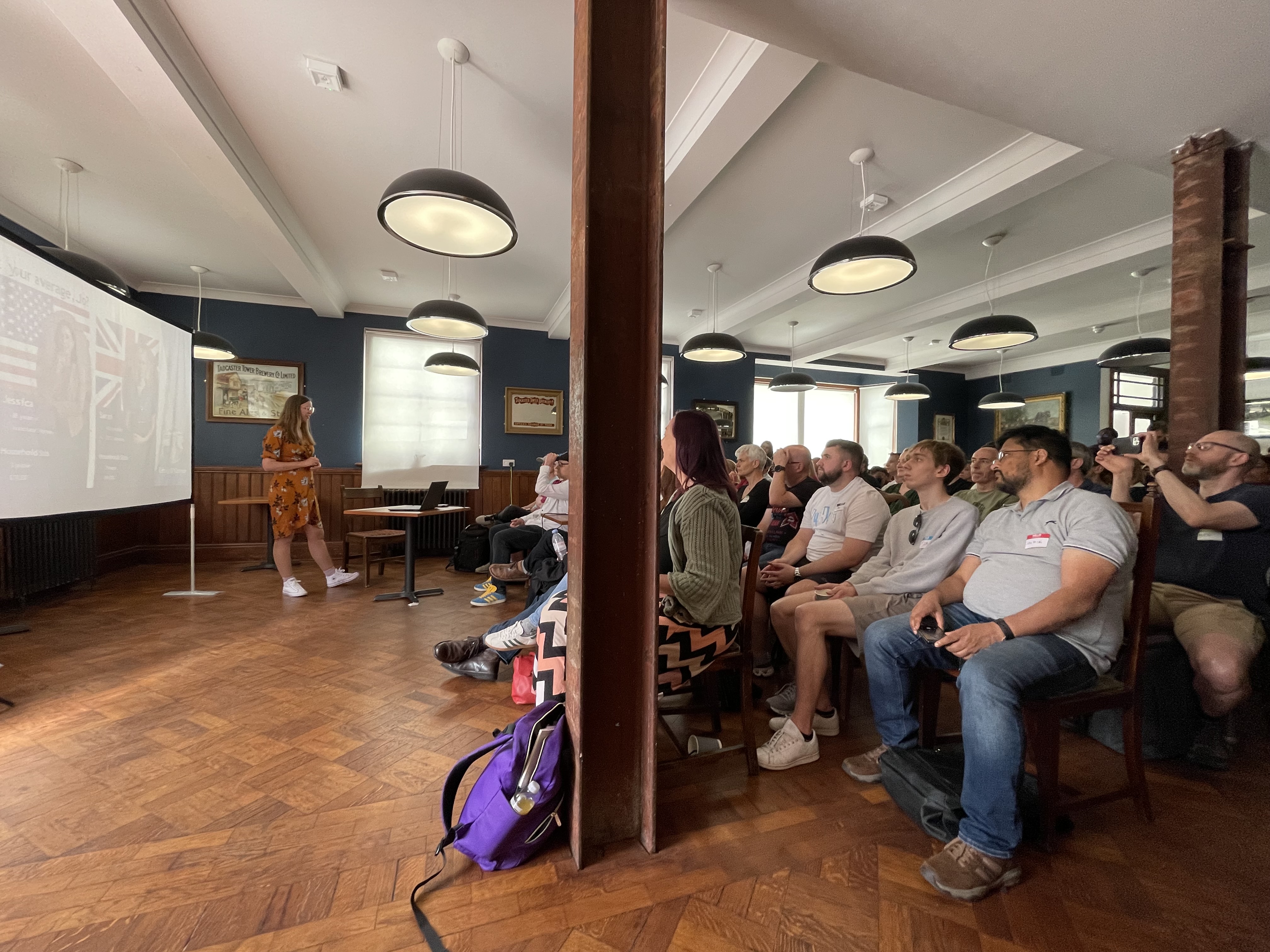 A photo of Emily O'Connor on stage at Leeds Atelier to a full crowd.