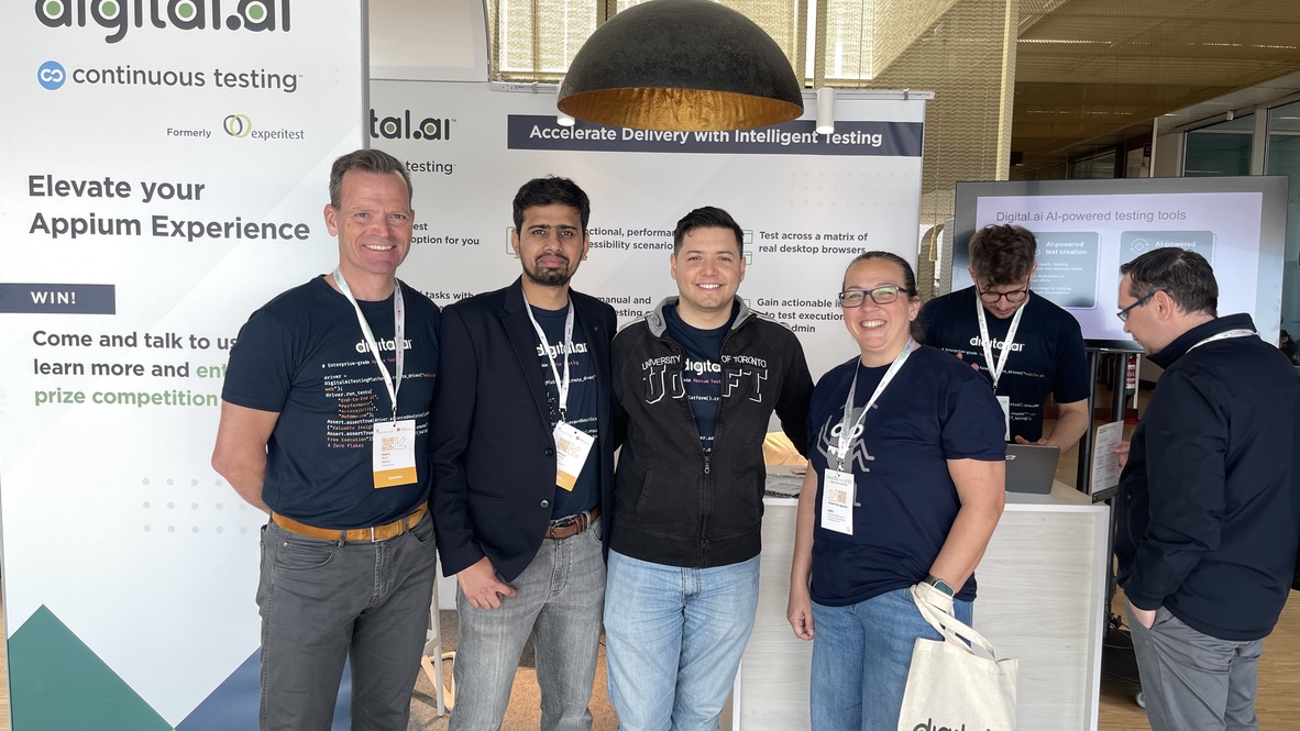Rosie poses with the friendly crew from digital.ai at their sponsor booth at Selenium Conference. Everyone’s smiling in front of banners about continuous testing and intelligent delivery, with some impressive swag on display.