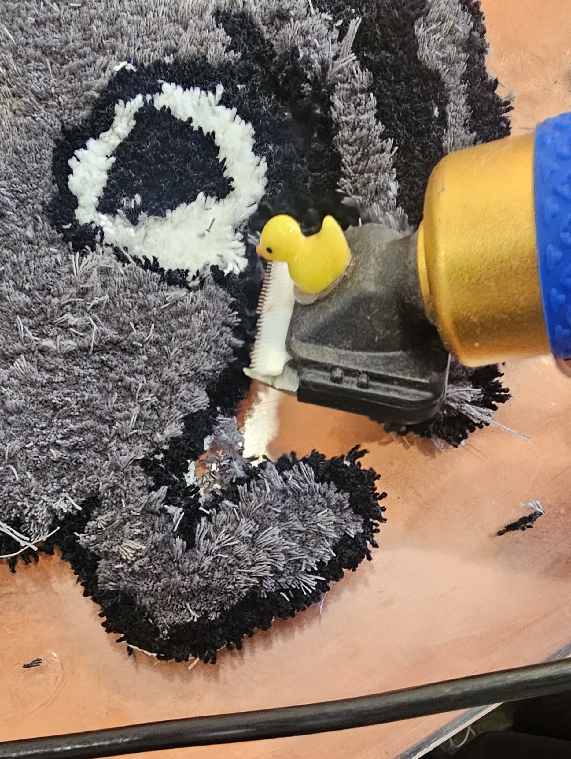 A yellow duck toy on a trimmer.

There is a large animated bug shaped rug where the eye is most visible.