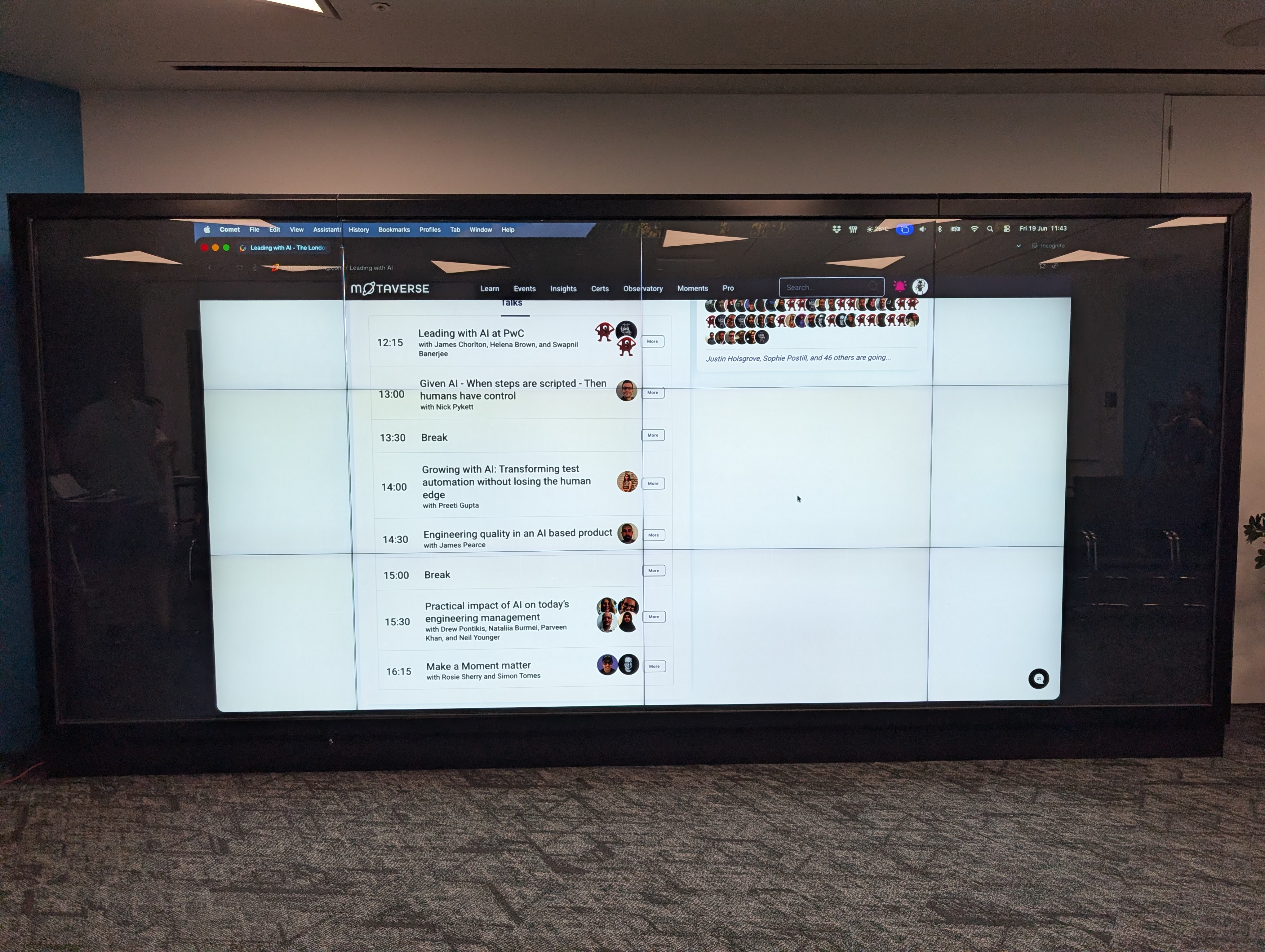A large presentation screen showing the schedule for the day image