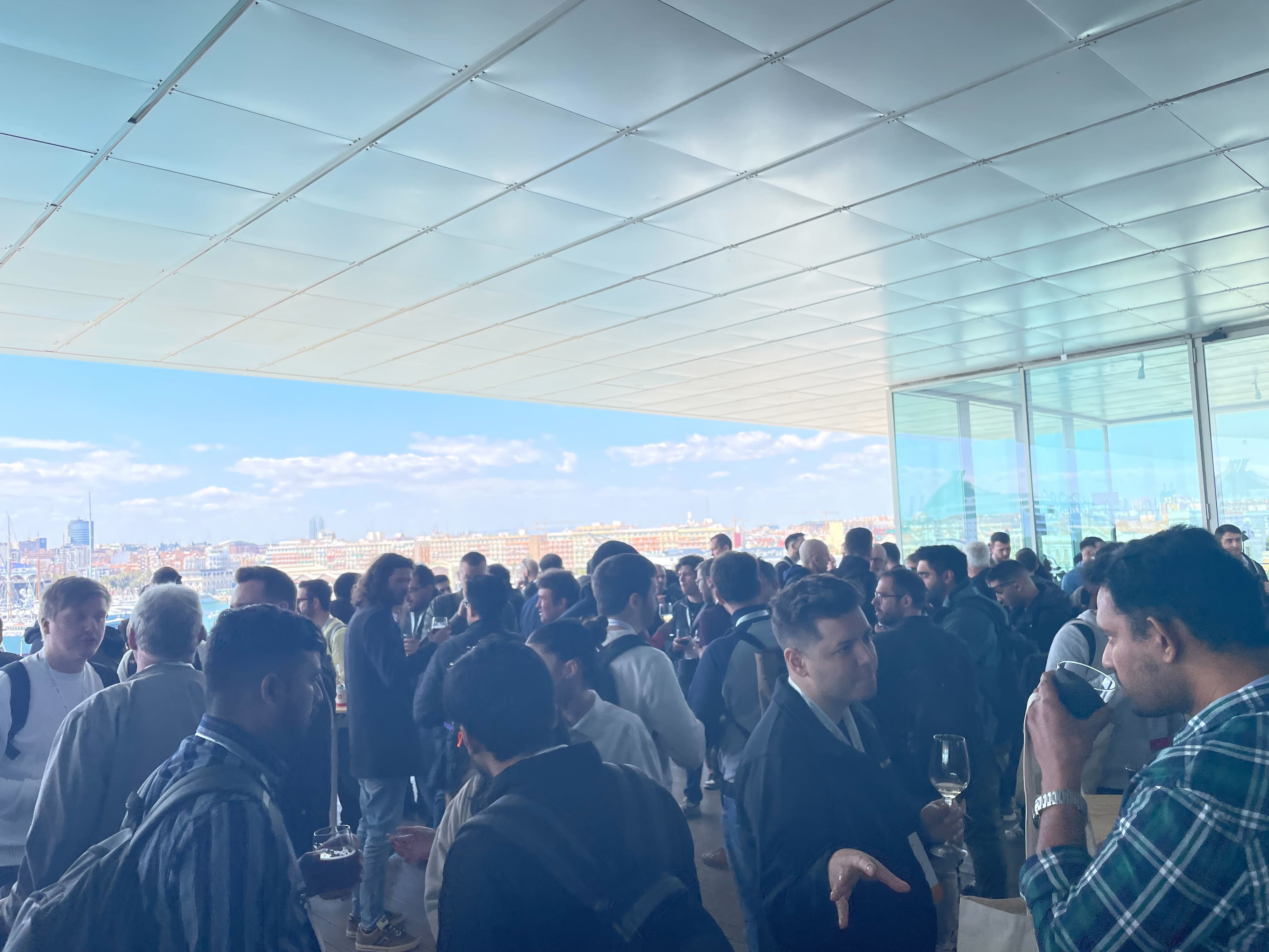 Photo of a crowd during break time at Selenium Conference with blue sky in the background.