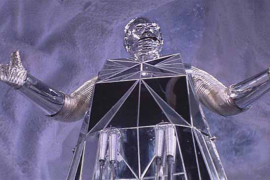 A 70s silver tin foil robot from logan's run (a wonderful 70's scifi film)
arms raised above his head. 
In the film... image