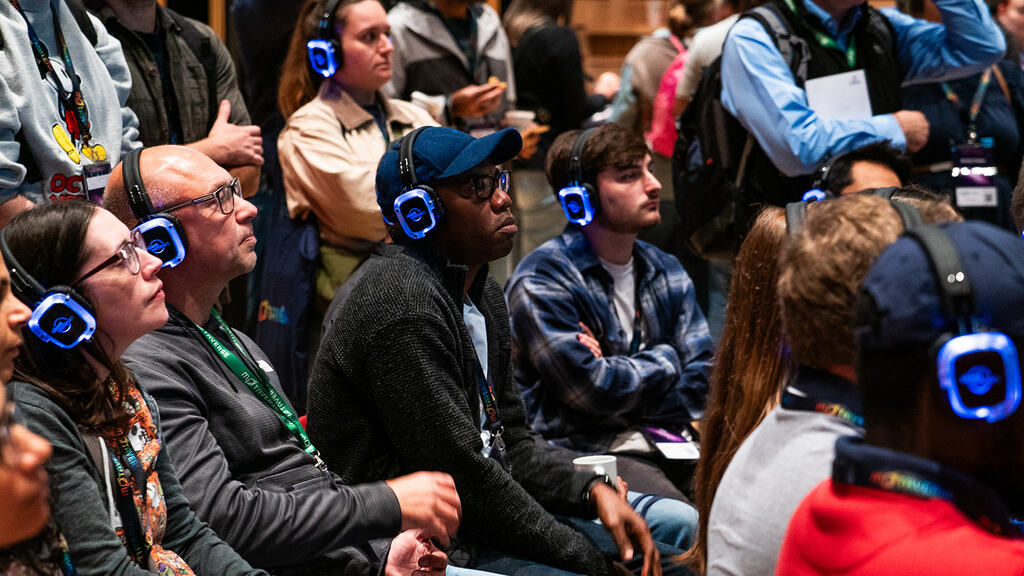 A full crowd listening in to Postman learnings with headphones on.