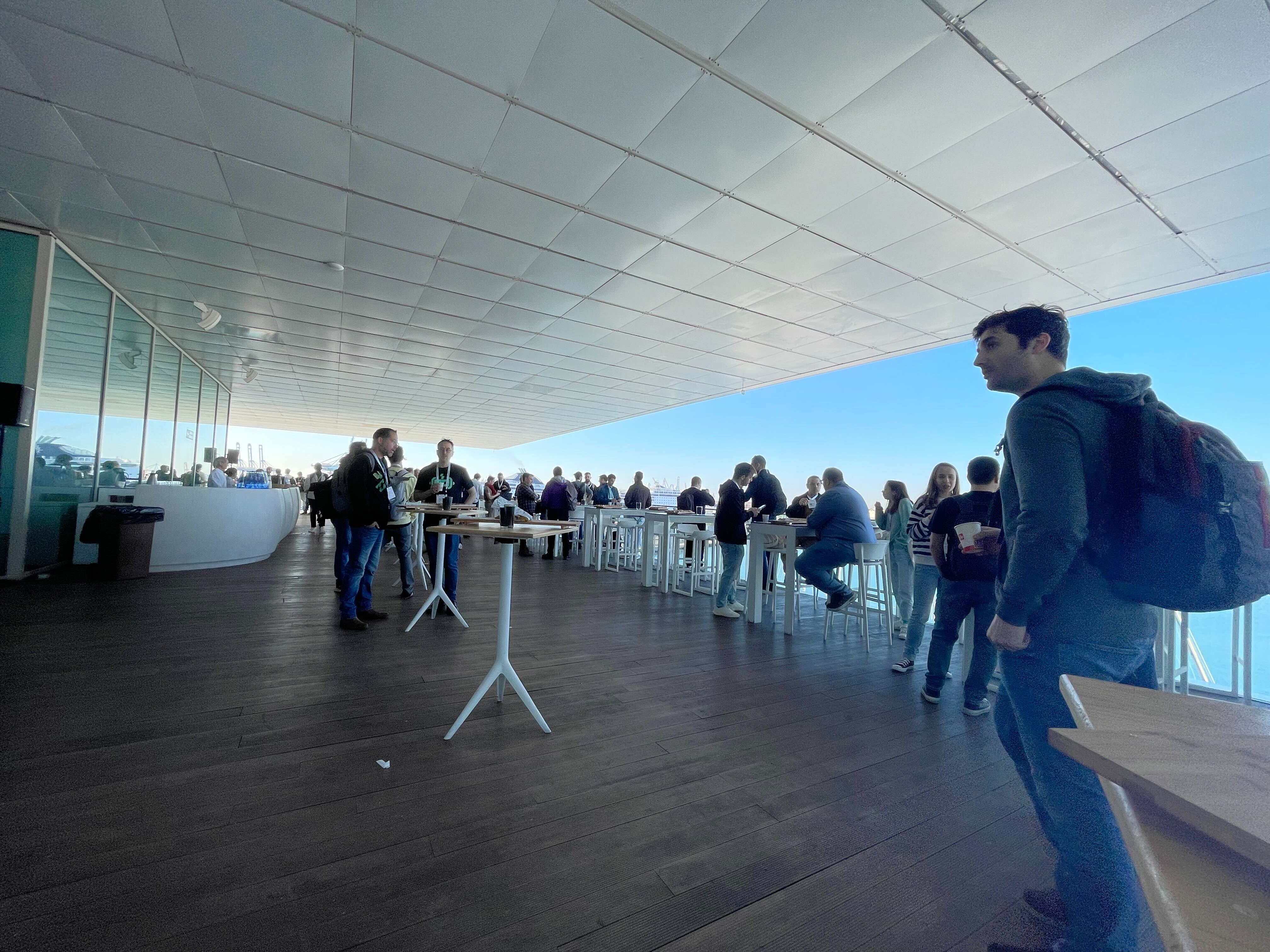 A photo of people having coffee and breakfast. There's a clear blue sky in the background.