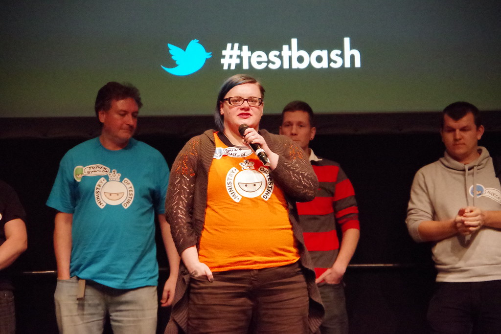 Guna Petrova on the TestBash stage, with a few others at the back of the stage waiting for their turn. image